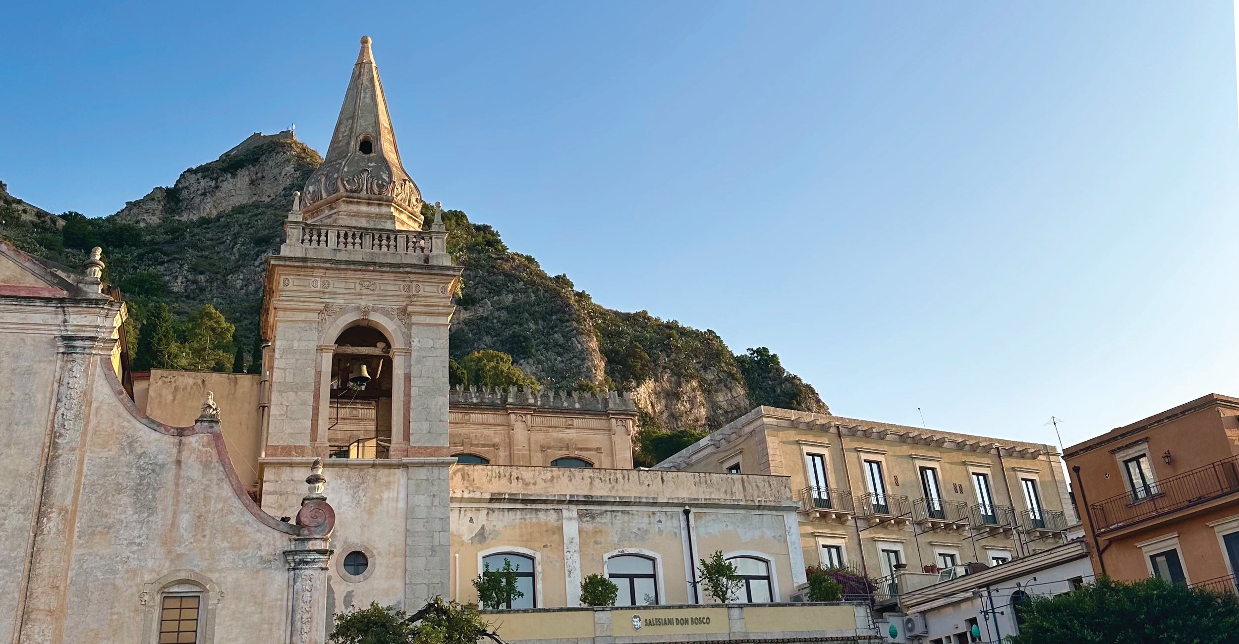 Historic building with bell tower and mountainous background